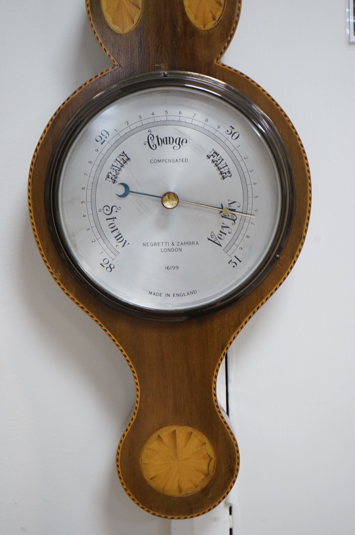 An Edwardian style inlaid mahogany Negretti & Zambra wheel barometer / thermometer, 82cm high